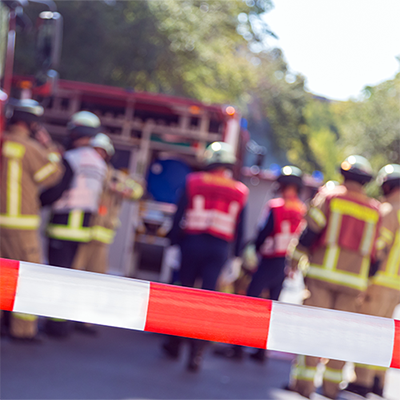 Tape marking an incident or crime scene with personnel standing in reflective vests.